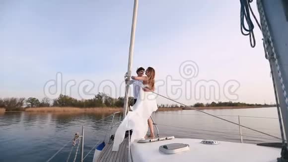 船长正在把穿着白色长裙的快乐女人抱在船上视频的预览图