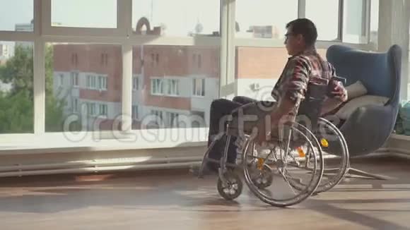 坐在轮椅上靠窗的残疾人视频的预览图