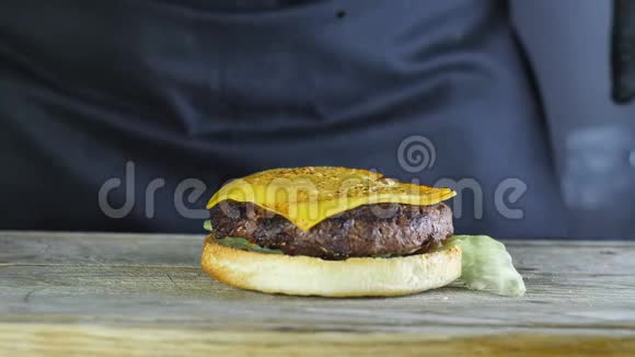 一个汉堡的半个面包的特写上面有一个生菜切片上面有两片奶酪上面有一个煤气炉视频的预览图
