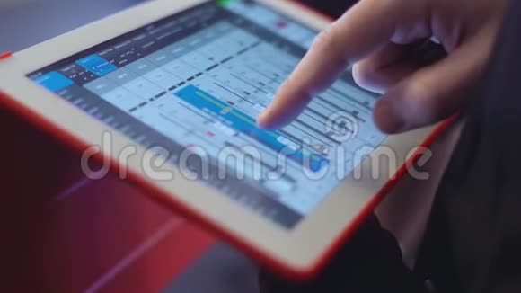 在平板电脑上配有混合控制台的人在事件音乐技术人员和设备概念上检查声音视频的预览图