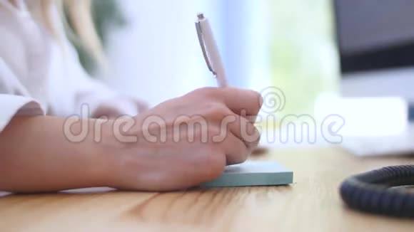 商人手握笔在办公室里键盘办公室视频的预览图