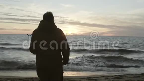 人在傍晚的沙滩上奔跑抛沙雄用波浪在海边欣赏大自然景观视频的预览图