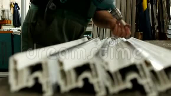 生产PVC窗的车间男工将PVC型材拧入以便进一步组装视频的预览图