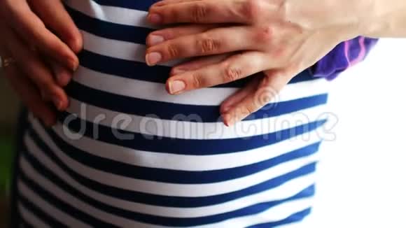 爸爸妈妈把手放在怀孕的肚子上怀孕夫妇抚摸怀孕的肚子准妈妈照顾视频的预览图
