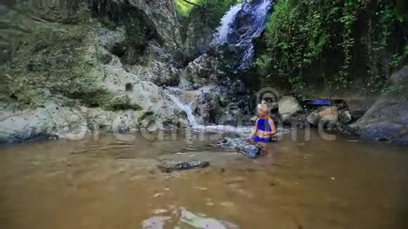 小金发女郎在瀑布流中畅游视频的预览图