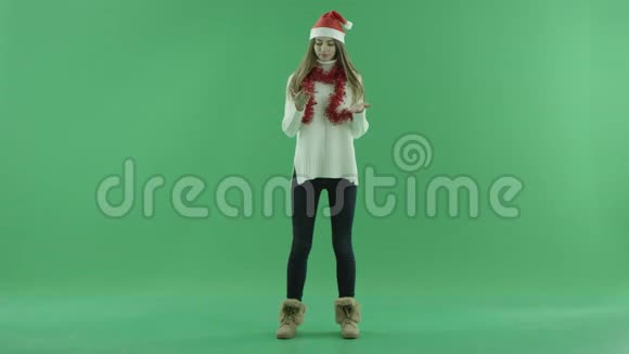 漂亮的宝贝戴着圣诞帽手上拿着雪花背景上拿着彩色钥匙视频的预览图