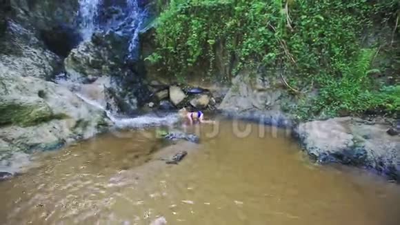 小女孩开始在瀑布流中游泳视频的预览图