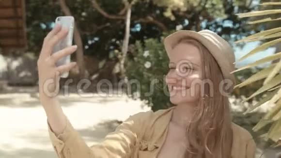 美丽的女人戴着帽子在度假时拍自拍照片视频的预览图