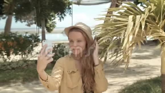 美丽的女人戴着帽子在度假时拍自拍照片视频的预览图