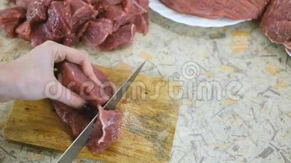 特写女人的手把大的多汁的牛肉切成小块烧烤慢动作视频的预览图