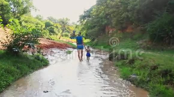 母亲和女儿在浅溪中与阳光一起散步视频的预览图