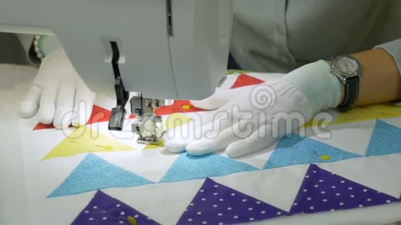 在缝纫机上工作一个戴白色手套的女人在织物上涂鸦视频的预览图