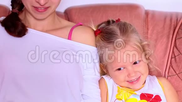 妈妈和女儿坐沙发玩得开心视频的预览图