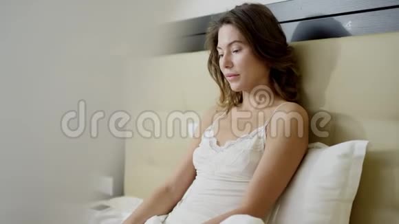 年轻快乐的女人在床上工作视频的预览图