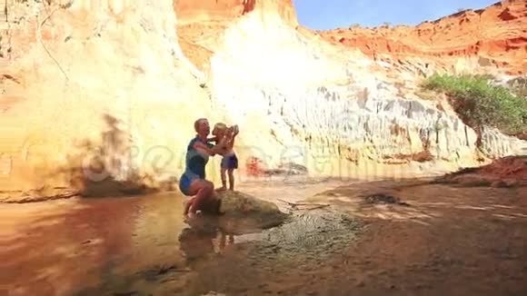 小女孩亲吻妈妈蹲在岩石做自我视频的预览图