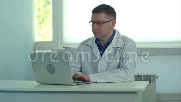 男医生在医院的白色办公桌上工作视频的预览图