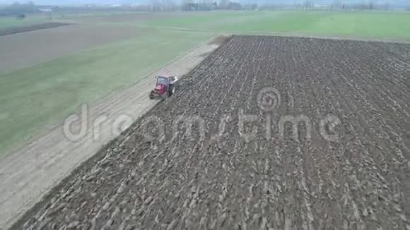 农业和农业早春拖拉机耕田的鸟瞰图视频的预览图