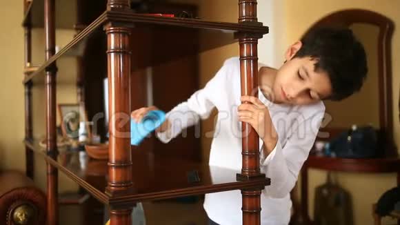 少年不情愿地把架子上的灰尘擦干净打扫孩子们房间房间里的混乱视频的预览图