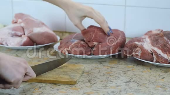 特写女人手拿一大块牛肉切成一小块烧烤视频的预览图