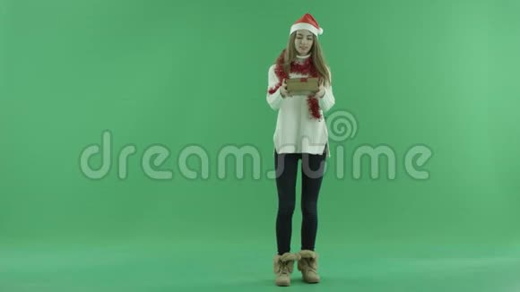 戴圣诞帽的年轻女性得到了非常好的圣诞礼物这使她在背景上快乐快乐视频的预览图