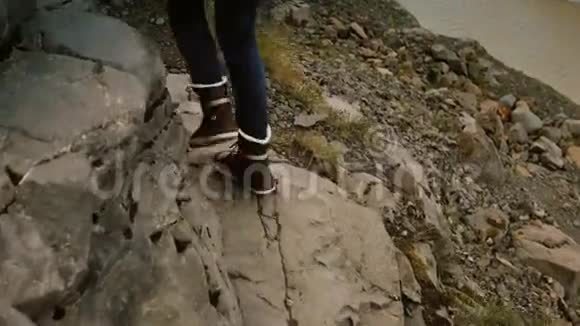 一群年轻人穿过岩石一起在冰岛的Vatnajokull冰湖附近的山上徒步旅行视频的预览图