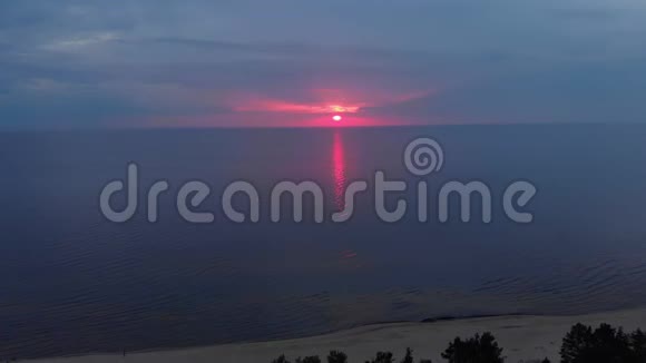 空中令人惊叹的黑暗风景生动的深红色罕见的红色日落与紫罗兰和洋红的颜色在波罗的海与小太阳视频的预览图
