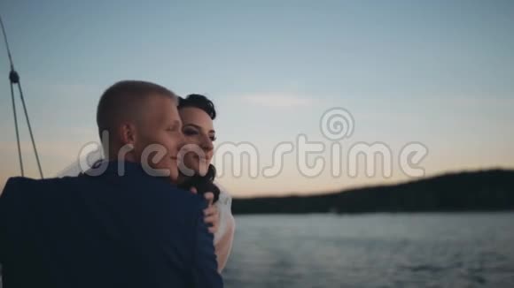 新婚夫妇在婚礼后的日落时分在游艇上航行浪漫的时候新郎新娘就在一起了视频的预览图