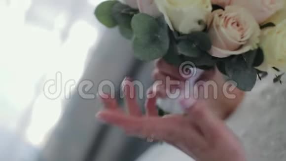 年轻女孩捧着新娘的花束特写镜头结婚花束年轻姑娘手中的美丽新娘花束视频的预览图