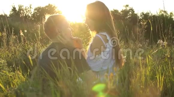 年轻夫妇在田野里接吻关于激情和爱的概念视频的预览图