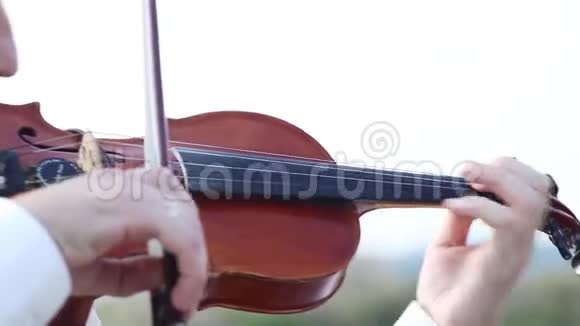 小提琴手在岩石高原上拉小提琴视频的预览图
