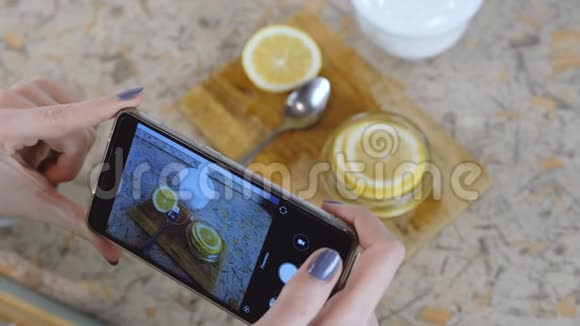 特写女人手与电话制作照片片柠檬在罐子里视频的预览图