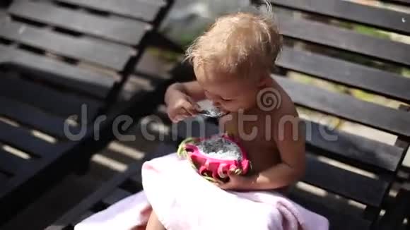 小可爱女孩在户外吃龙果视频的预览图