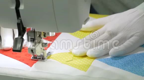 双手戴白手套把织物缝在缝纫机上视频的预览图