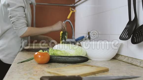 不可辨认的女人在厨房里洗蔬菜洋葱西红柿作为沙拉侧视视频的预览图