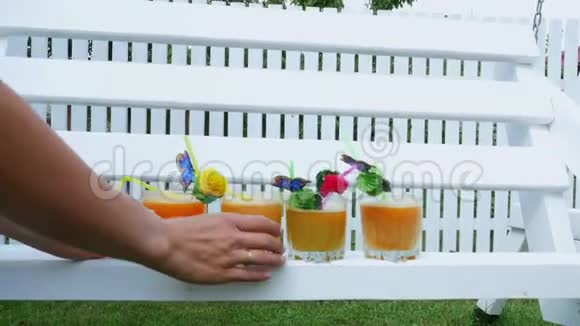 夏天在花园里父母爸爸妈妈端着刚榨好的果汁给孩子治病家庭视频的预览图