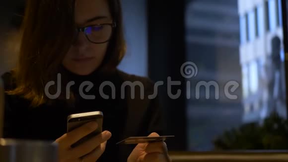 美丽的女性网上银行使用智能手机在线购物与信用卡在家里的生活方式技术和技术视频的预览图