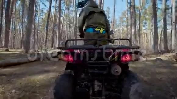一个喜欢极限驾驶的年轻人骑着四轮自行车穿过秋天的森林克服了秋天森林上的小障碍视频的预览图