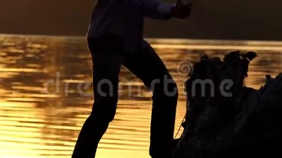在灿烂的夕阳下一个金发男人在湖畔跳舞视频的预览图