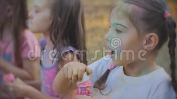 快乐的小女孩吹着肥皂泡在街上笑视频的预览图