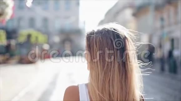 迷人的年轻女人穿着一件漂亮的白色连衣裙头发散乱有魅力的年轻女士正在城里奔波视频的预览图