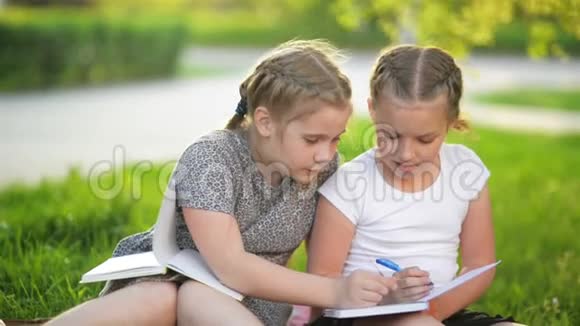 女孩在夏天的花园里做作业他们在获得知识方面玩得很开心视频的预览图