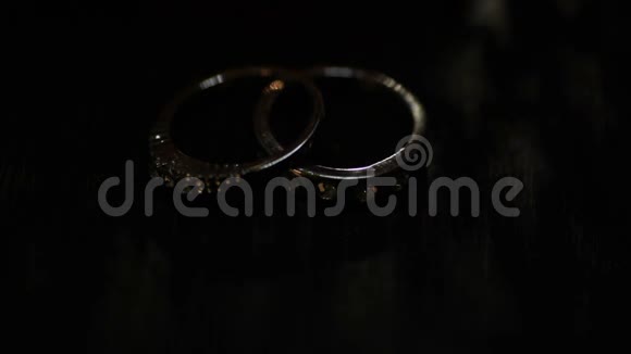 两枚结婚戒指在牛皮纸盒上黑暗景象视频的预览图