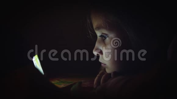 小女孩晚上看动画片视频的预览图
