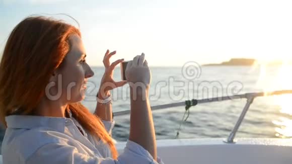 年轻女子在坐船时用相机拍手机视频的预览图