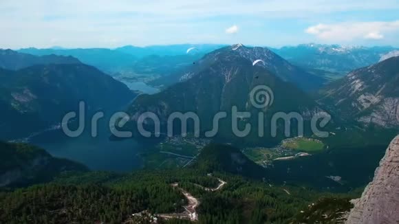 奥地利雪山白色降落伞飞行滑翔伞的鸟瞰图视频的预览图