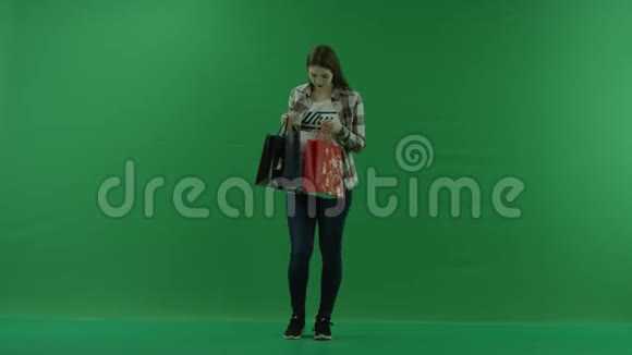 女孩在绿色屏幕上的袋子里找东西视频的预览图