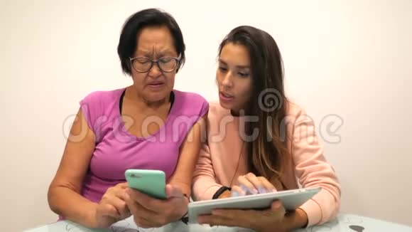 年轻的混血女孩用手机给她的亚洲老母亲展示一些东西4K视频的预览图