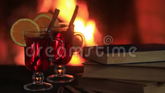 热覆盖葡萄酒和一本书在桌子上背景上有火的壁炉视频的预览图