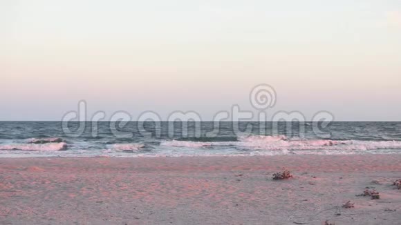 海浪在沙滩上海边日落时不平静的大海上视频的预览图