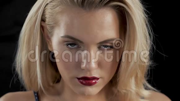 美丽的女人有着明亮的魅力化妆红唇和指甲金发干净的皮肤深色背景模特视频的预览图